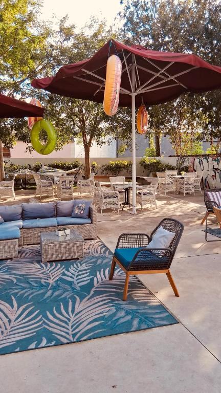Patio with umbrellas, sofas and an outdoor rug at Atrium